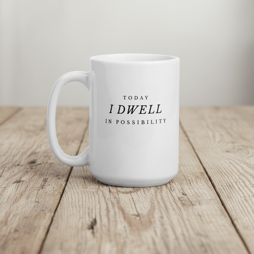White mug with text 'Today I Dwell in Possibility' on a wooden surface in 15 oz