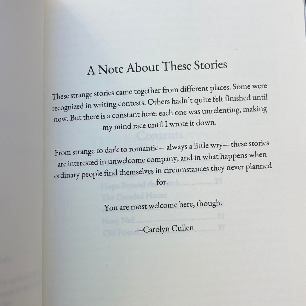 An open book showing a printed page with the heading 'A Note About Three Stories' and several paragraphs of text, photographed against a dark background.
