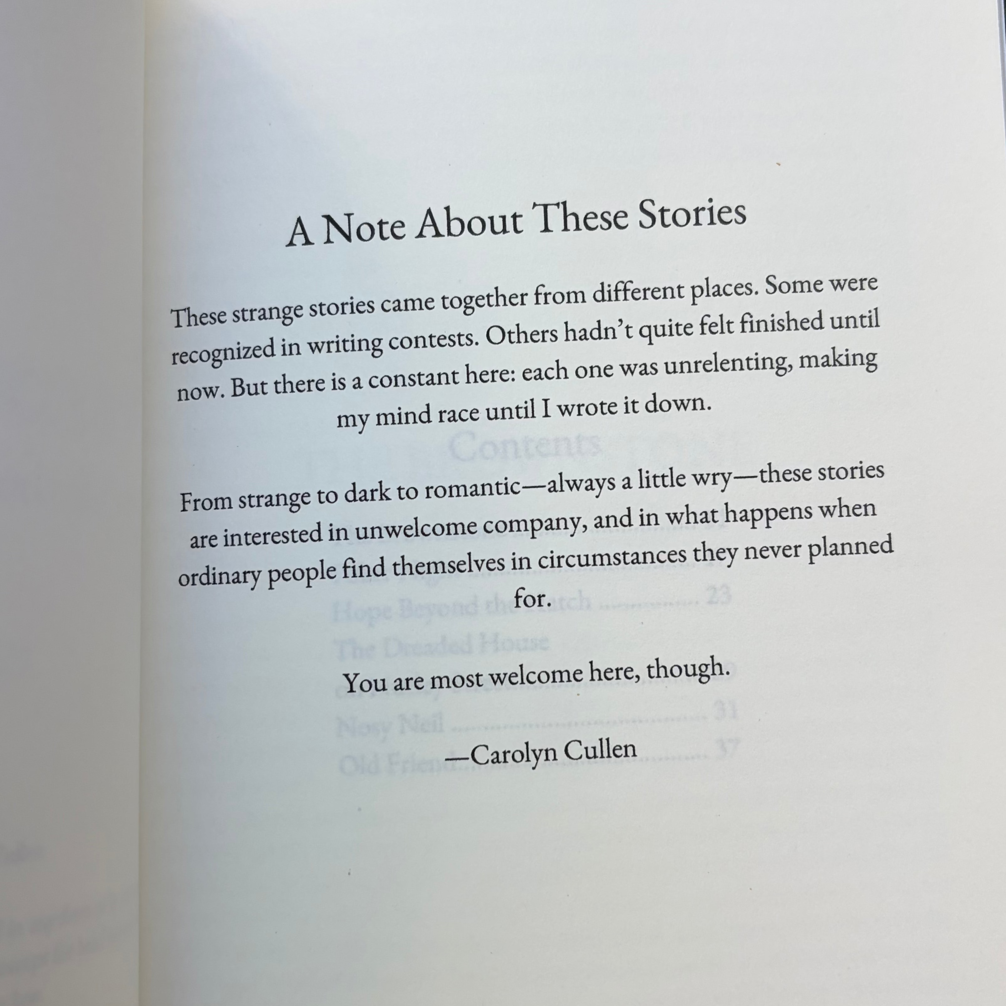 An open book showing a printed page with the heading 'A Note About Three Stories' and several paragraphs of text, photographed against a dark background.