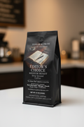 Poplar & Prose Editor's Choice coffee package on a blurred kitchen counter background