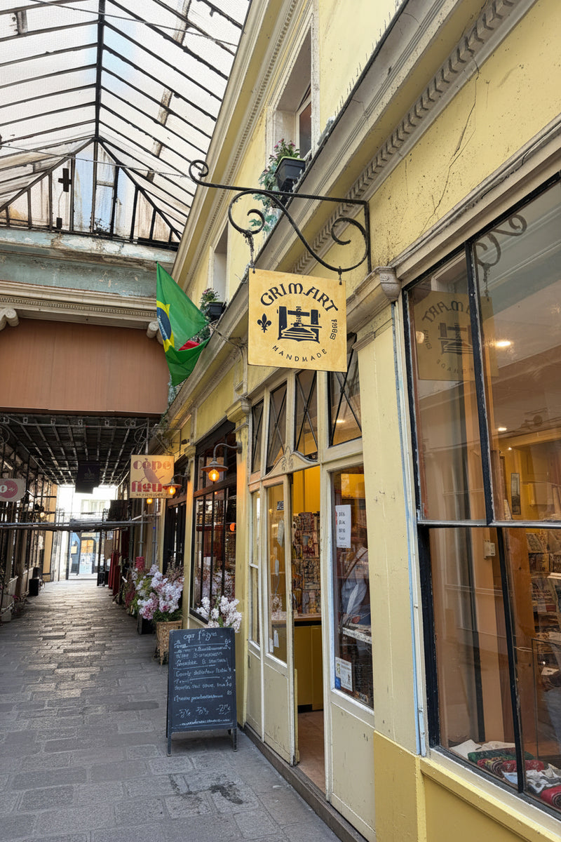 A real-world street market scene with  a yellow building with a hanging sign reading 'Grimart.' 