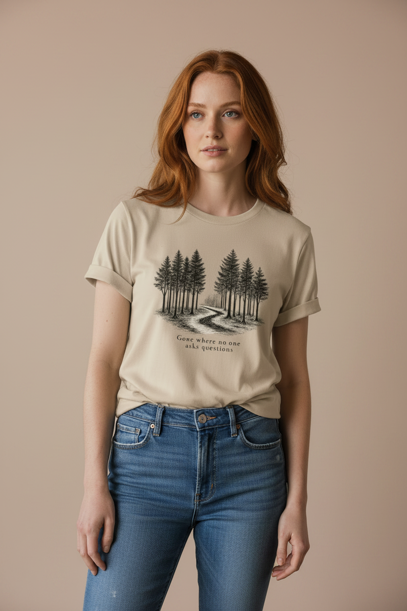Woman wearing a beige grove t-shirt with a forest graphic and text, standing against a beige background