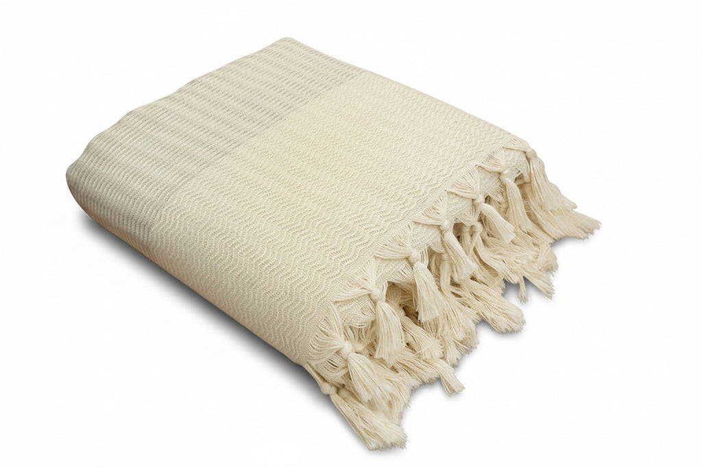 Lilac woven blanket with tassels on a white background