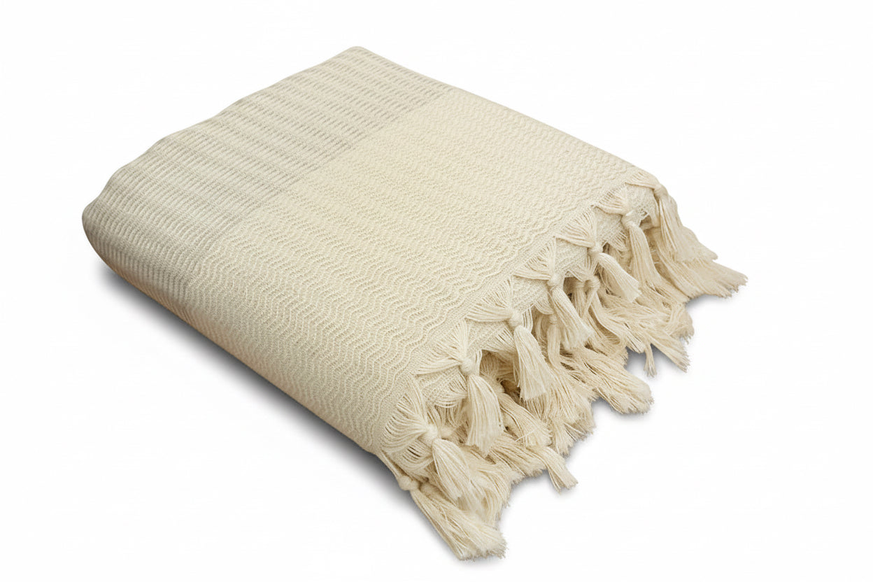Lilac woven blanket with tassels on a white background