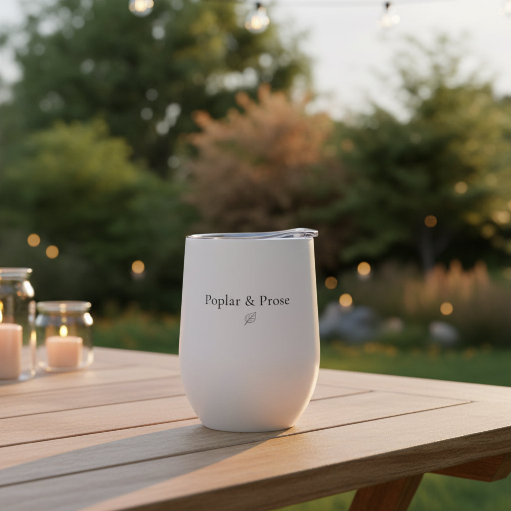 Poplar & Prose logo side of tumbler with lid outdoors in a garden