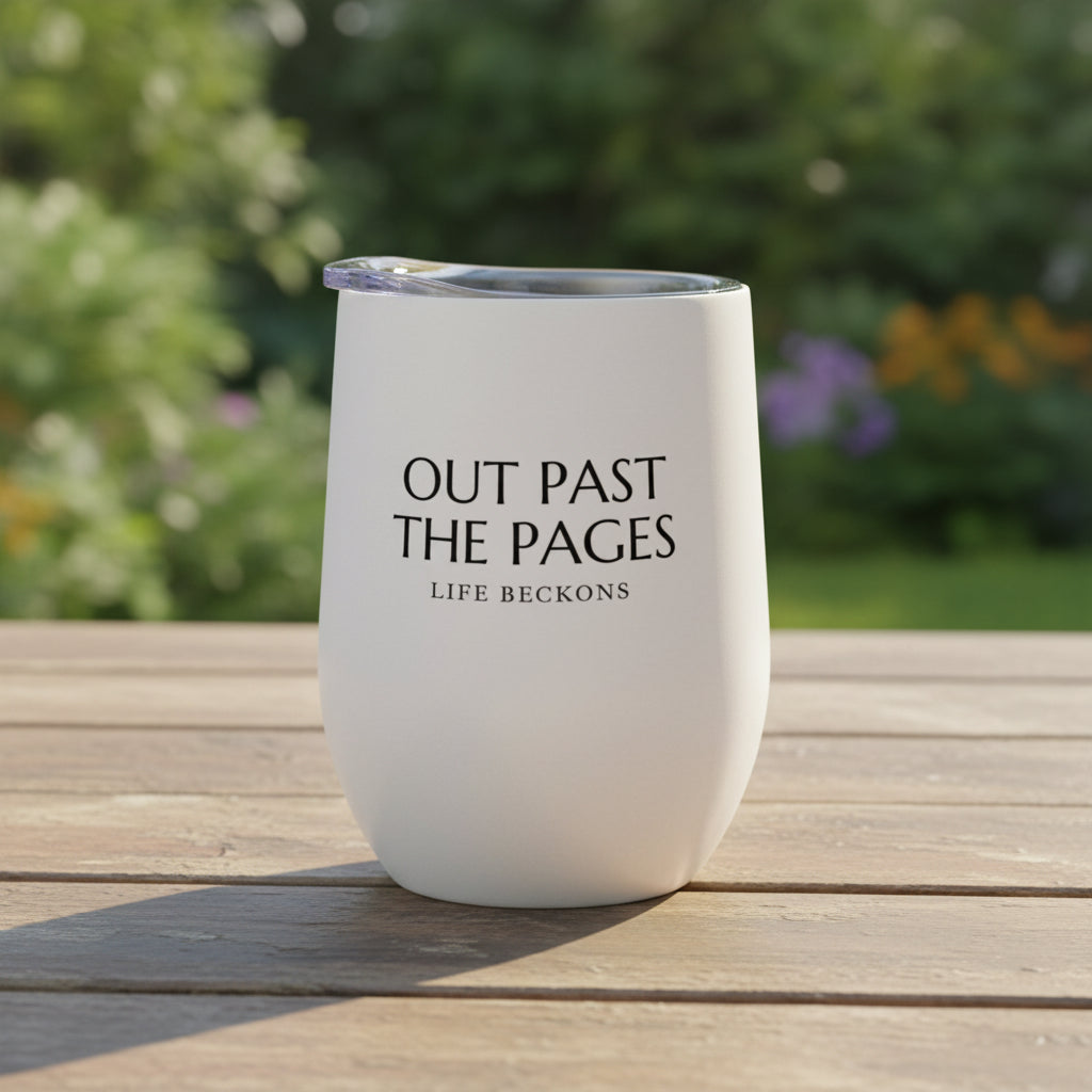 tumbler in a garden on an outdoor table with the phrase "out past the pages/life beckons"