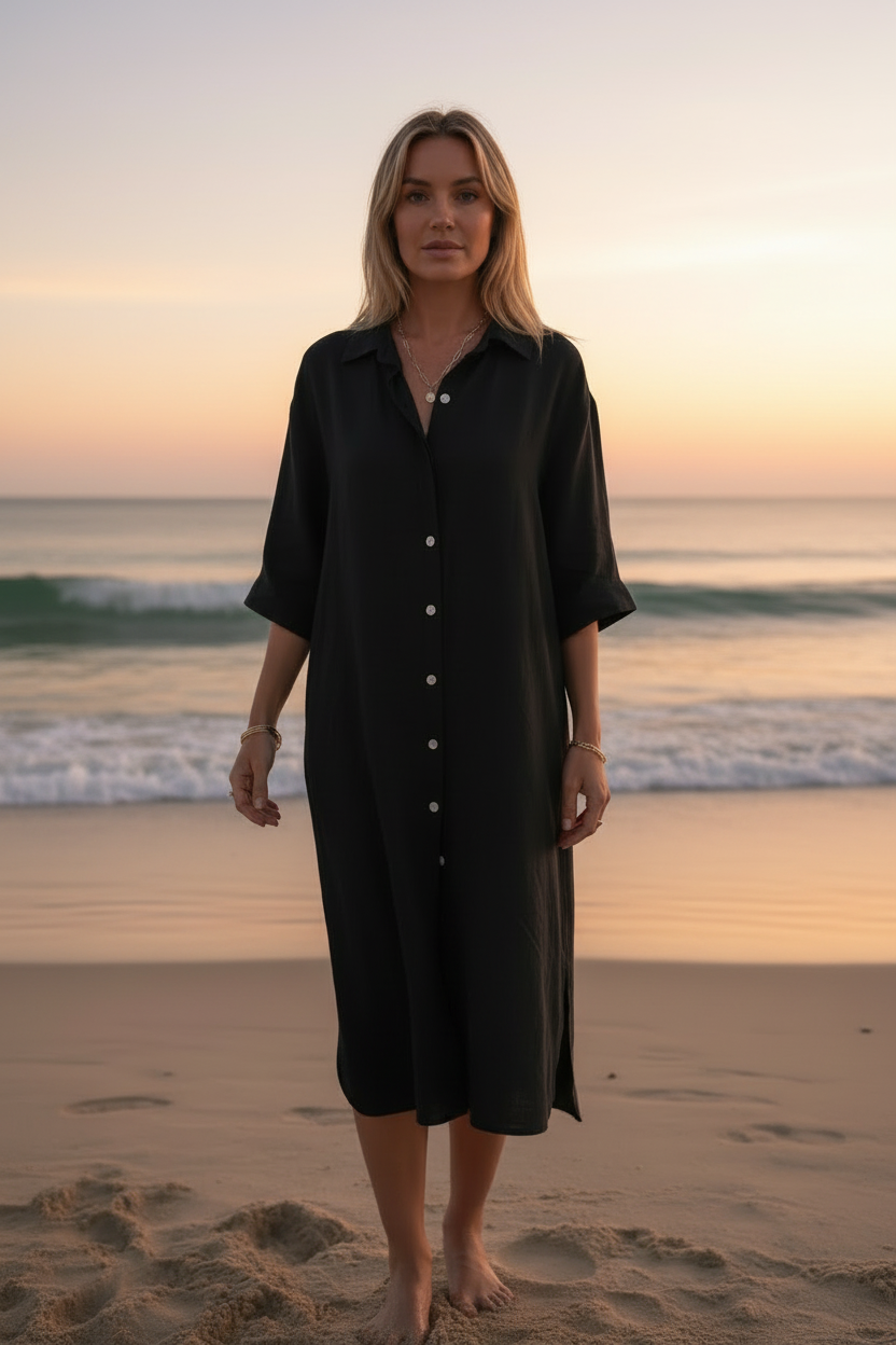 Woman wearing a the Shoreline Linen Shirtdress on a beach at sunset
