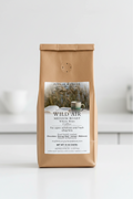 Compostable paper coffee bag with a Wild Air Whole Bean label on a white background