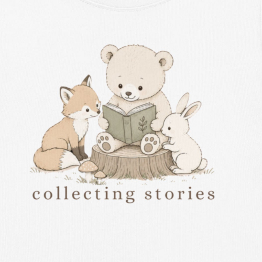 A white graphic print featuring a cute illustration of a teddy bear reading a book on a tree stump, with a fox on the left and a rabbit on the right. Below the illustration, the text 'collecting stories' is printed in a brown serif font.