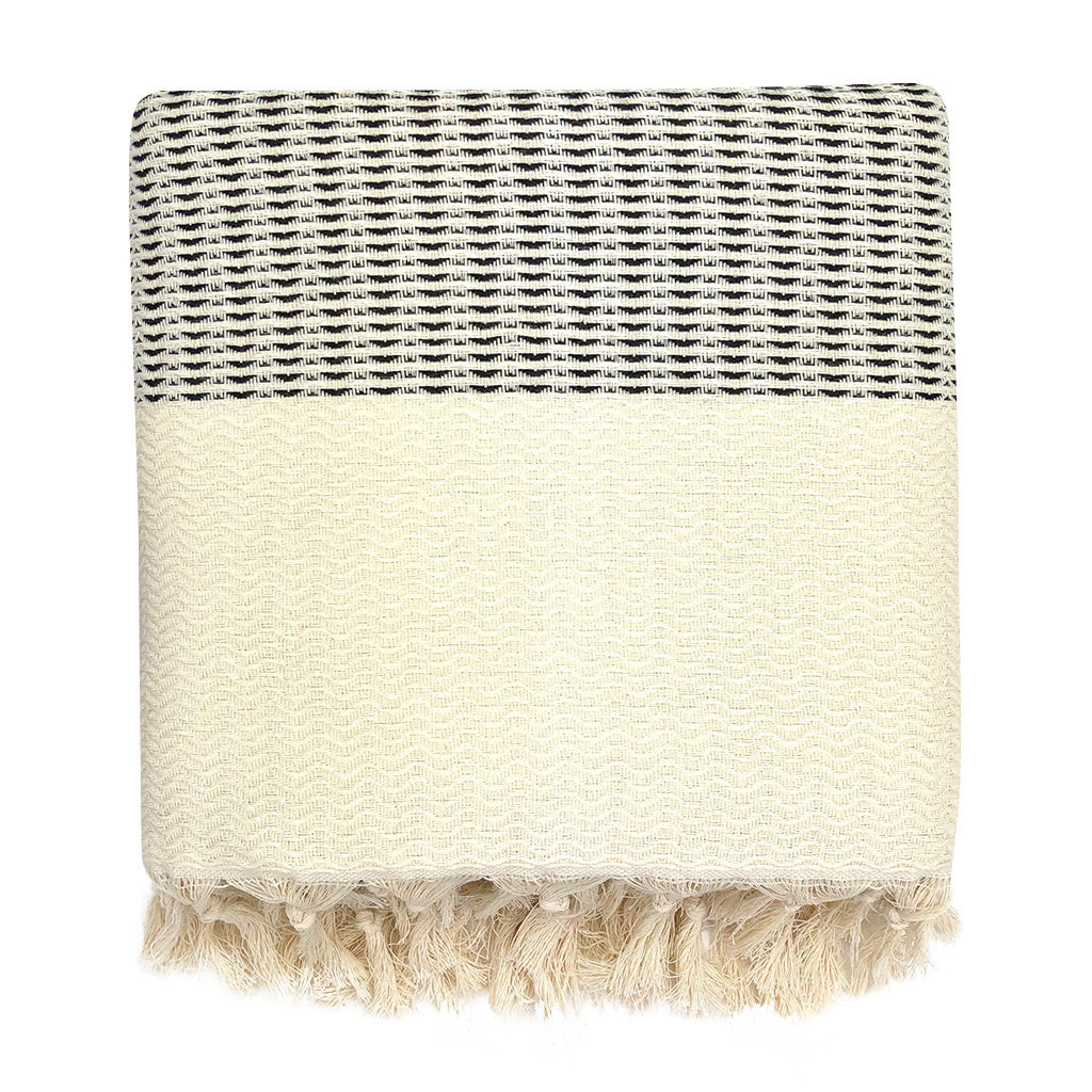 Woven Turkish Cotton blanket with black and white stripes and tassels on a white background