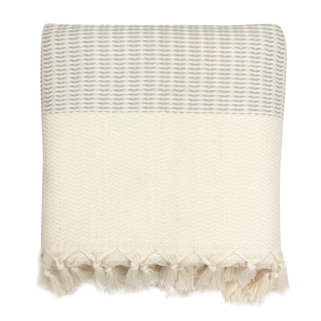 Textured lilac Turkish Cotton blanket with a striped pattern and tassel trim on a white background