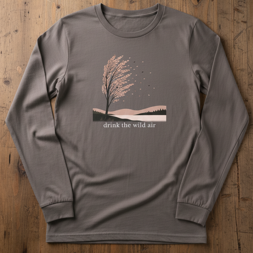 gray long sleeve tee with sweeping tree illustration on reclaimed wood table. Text reads 'drink the wild air'