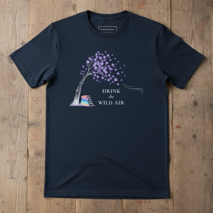 navy tee with bending tree blowing int he wind, a stack of books resting underneath, and text 'drink the wild air'