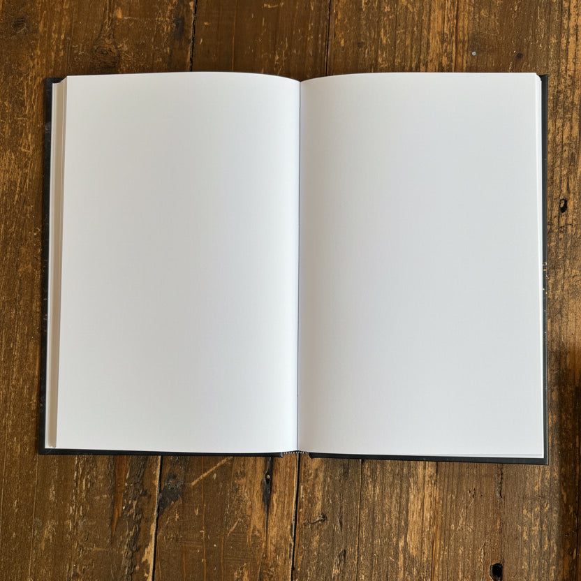 An open blank notebook with white pages,  on a rustic wooden table.