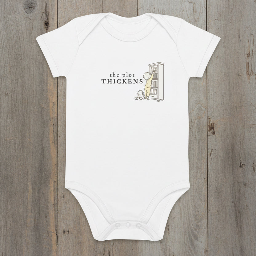 white bodysuit with 'the plot thickens' and illustration