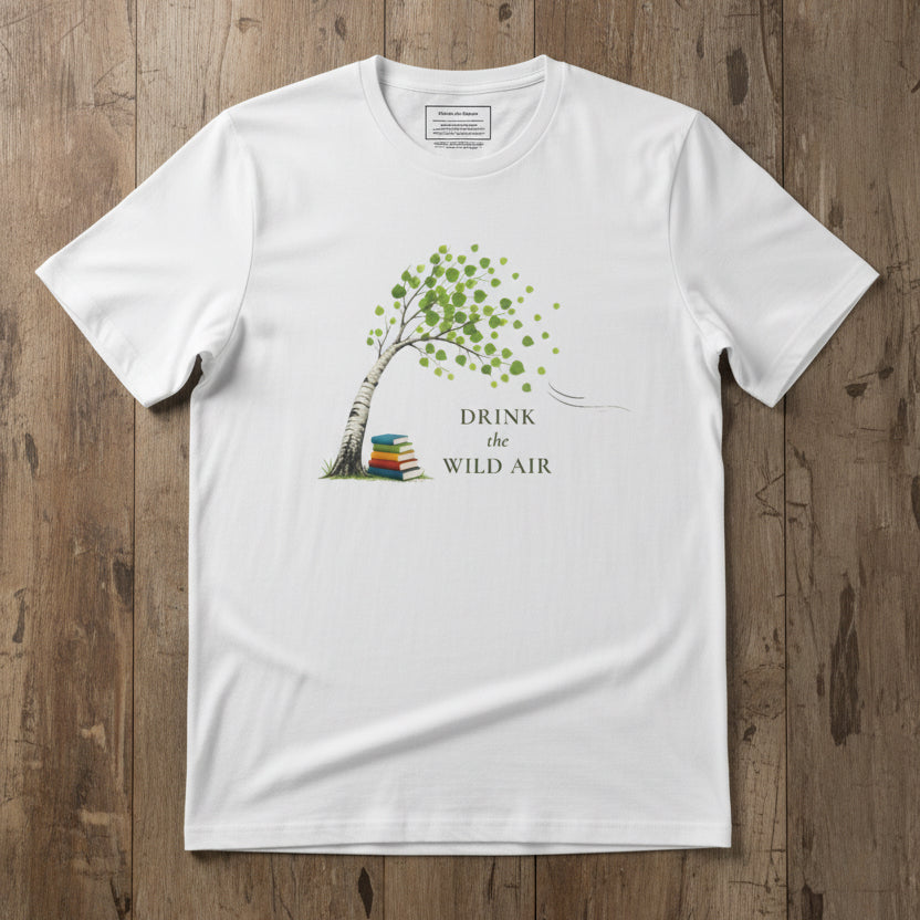 white tee with tree and books blowing in the wind illustration and text 'drink the wild air'